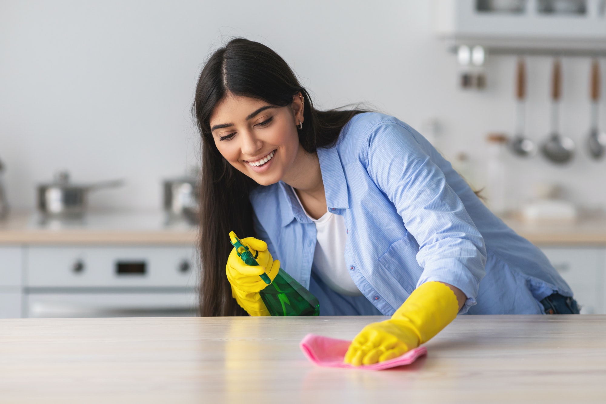 cheerful-young-woman-cleaning-table-with-cloth.jpg